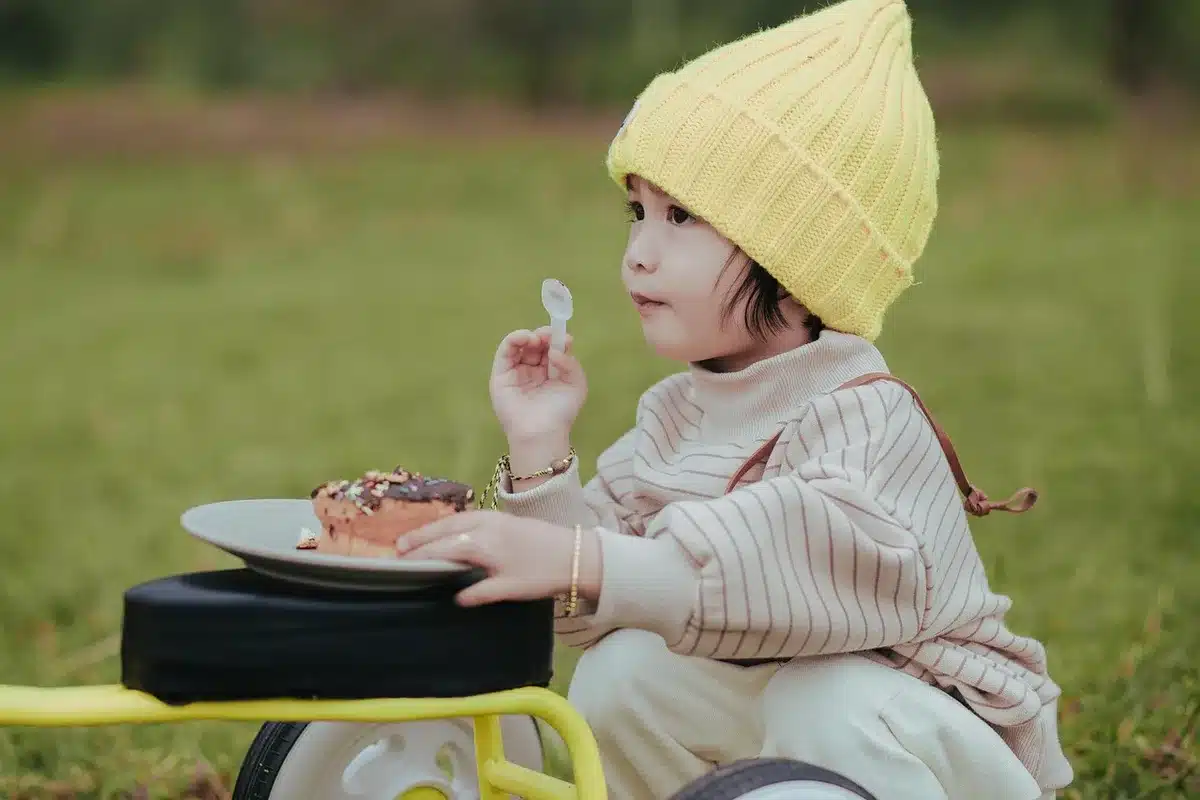 Enfant assis à table, surveillé pendant le repas sans distraction