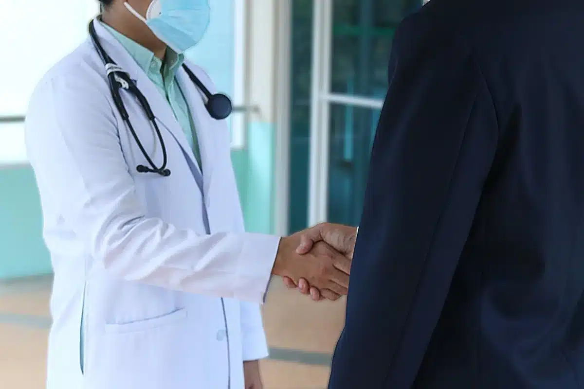 Patient en consultation médicale avec thermomètre indiquant fièvre