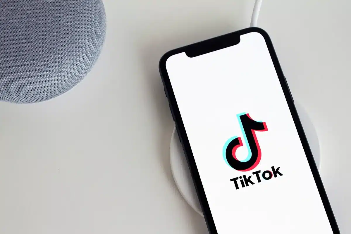 Main d'adolescent tenant un smartphone montrant un flux infini de contenu