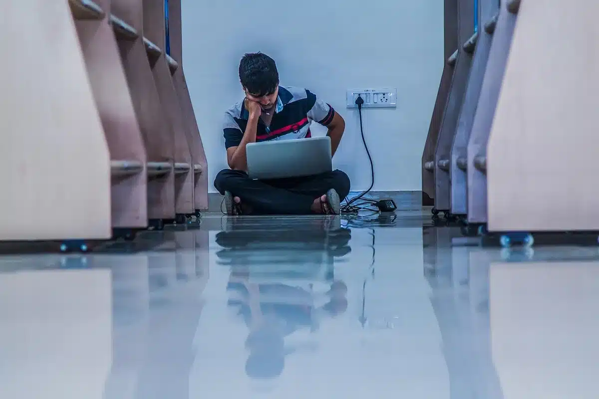Personne assise seule, tête baissée, illustrant perte d'intérêt et isolement social