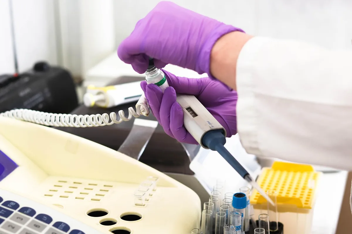Tubes de prélèvement et résultat d'un bilan thyroïdien sur une table de laboratoire