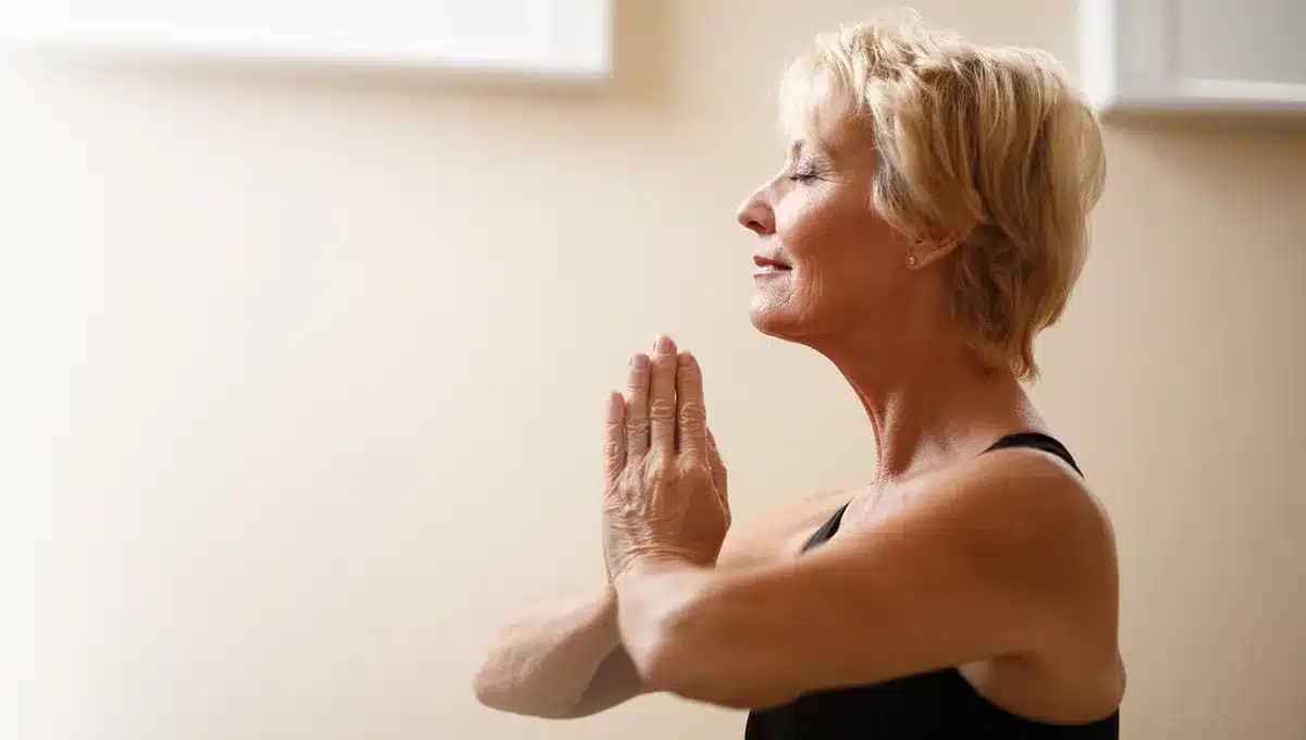Personne pratiquant des exercices de respiration près d'une fenêtre en journée