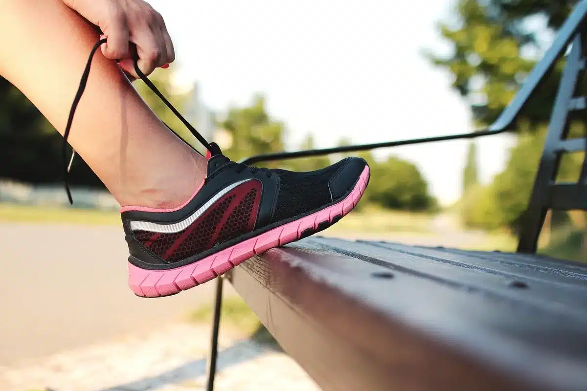 Personne préparant ses chaussures de course près d'une fenêtre en journée