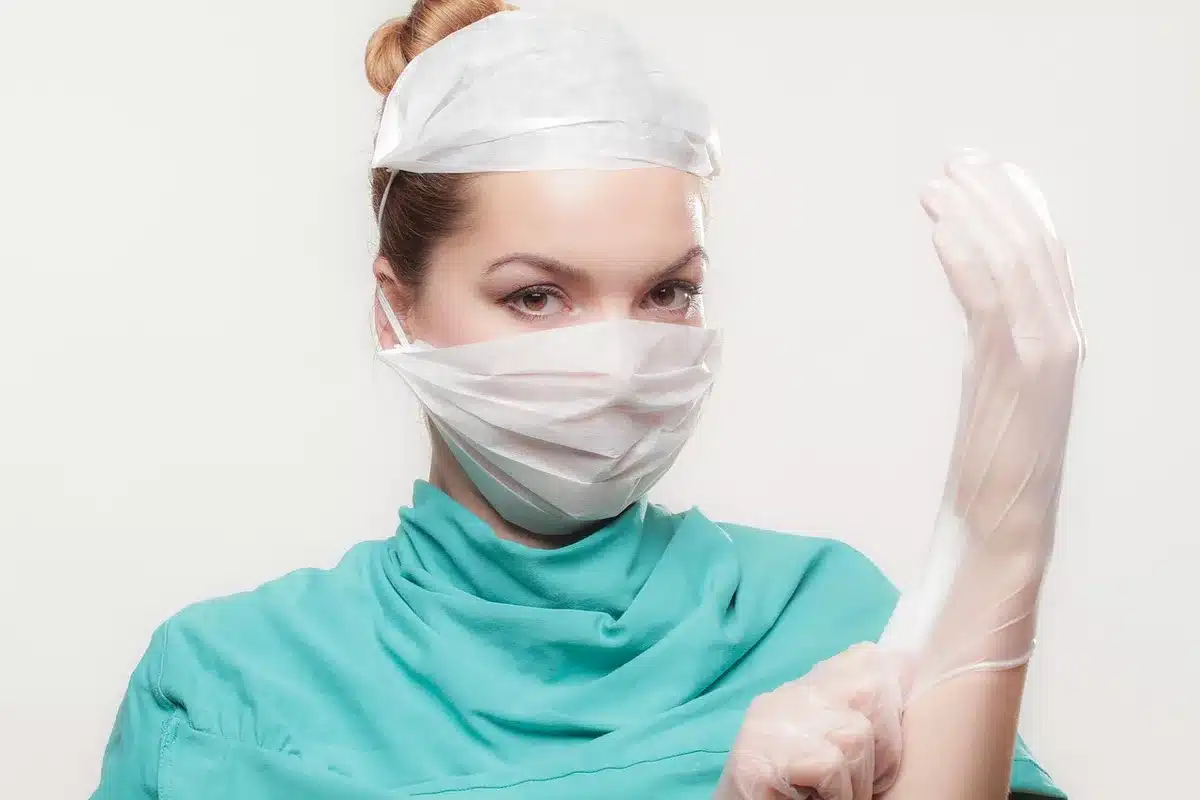 Médecin anonymisé rapprochant une chaise du lit pour s'asseoir en face du patient