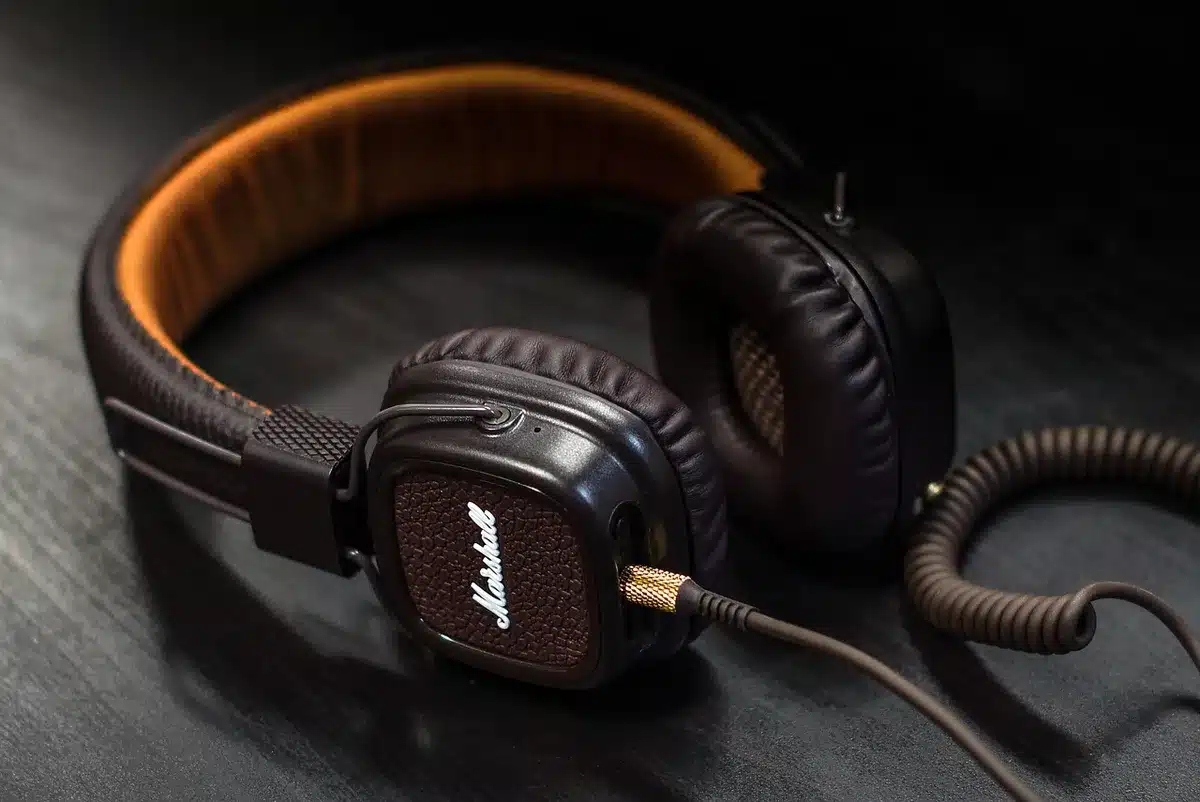 Ordinateur portable avec casque et fiche de notes sur une table en plein jour