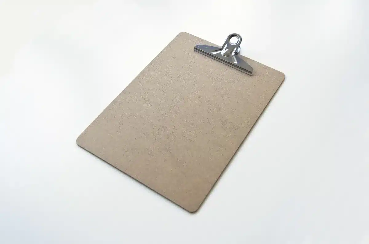 Préparation d'une téléconsultation avec carnet de notes et thermomètre près d'une tablette